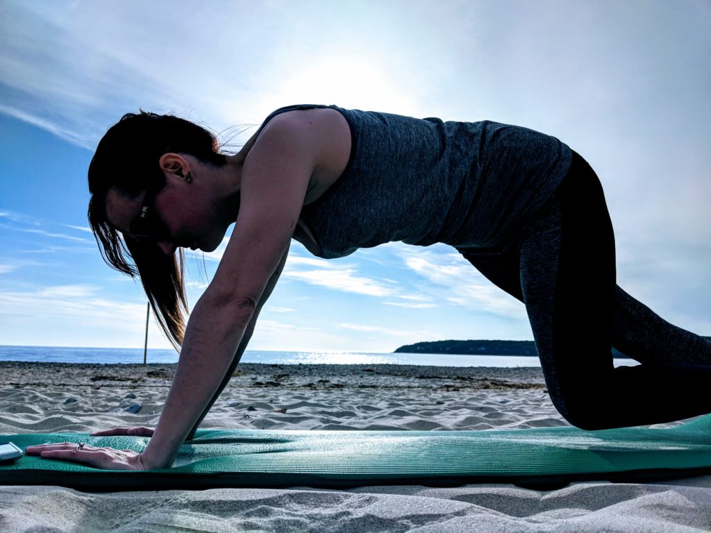 woman doing yoga on the beach